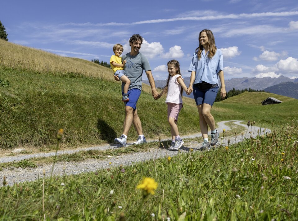 A family with children enjoys a walk on a narrow path.