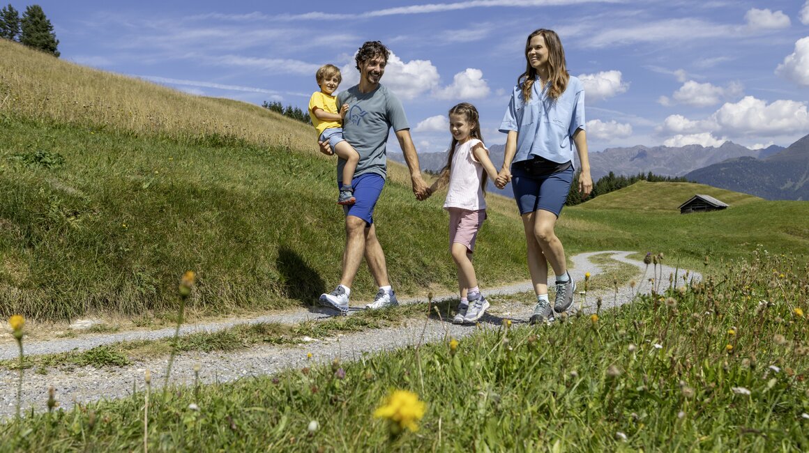 A family with children enjoys a walk on a narrow path.