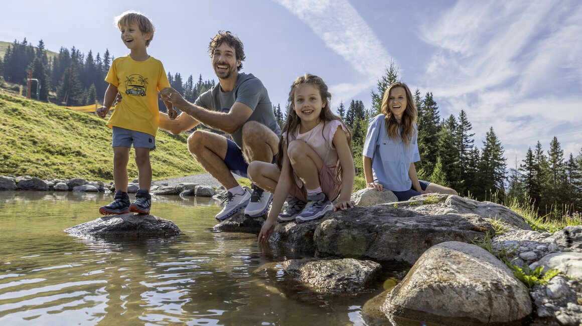 A cheerful family enjoys a playful day by the water.