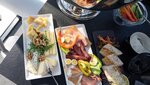 Bunte Auswahl an Käse, Wurst und frischem Gemüse auf einem Tisch.