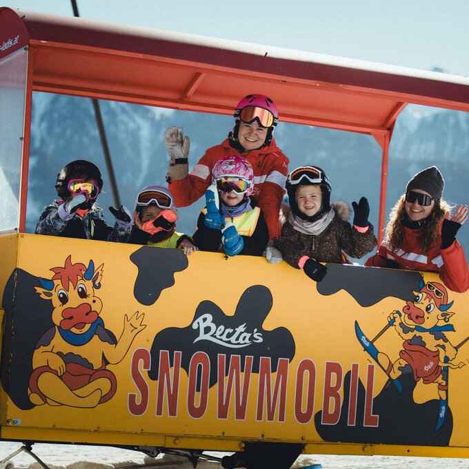Kids and mentors in a snowmobile lift in the mountains.