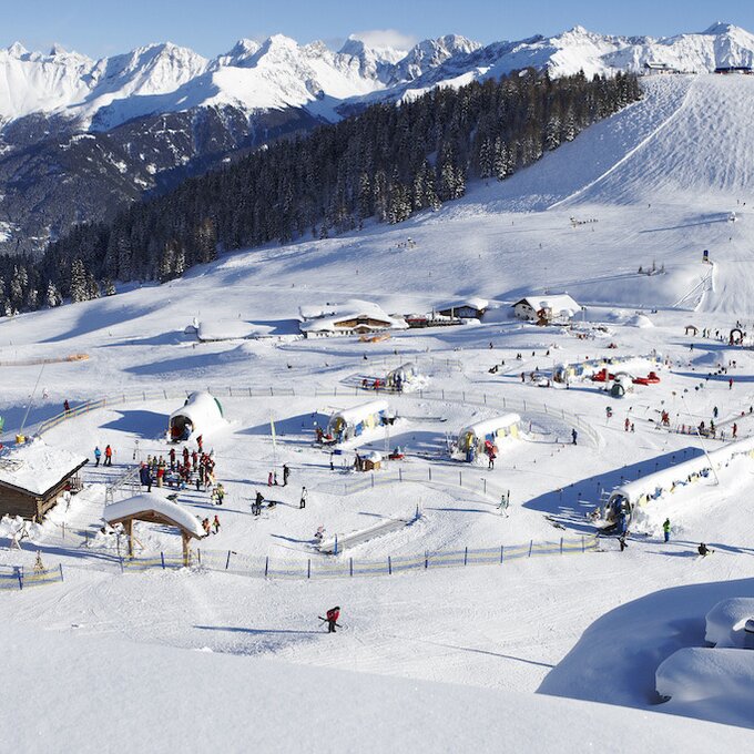 Snow-covered mountains featuring a ski resort and numerous skiers.