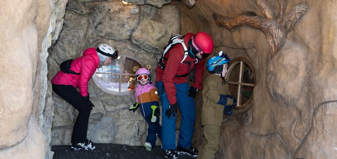 Family with children in a play area designed to look like a cave.