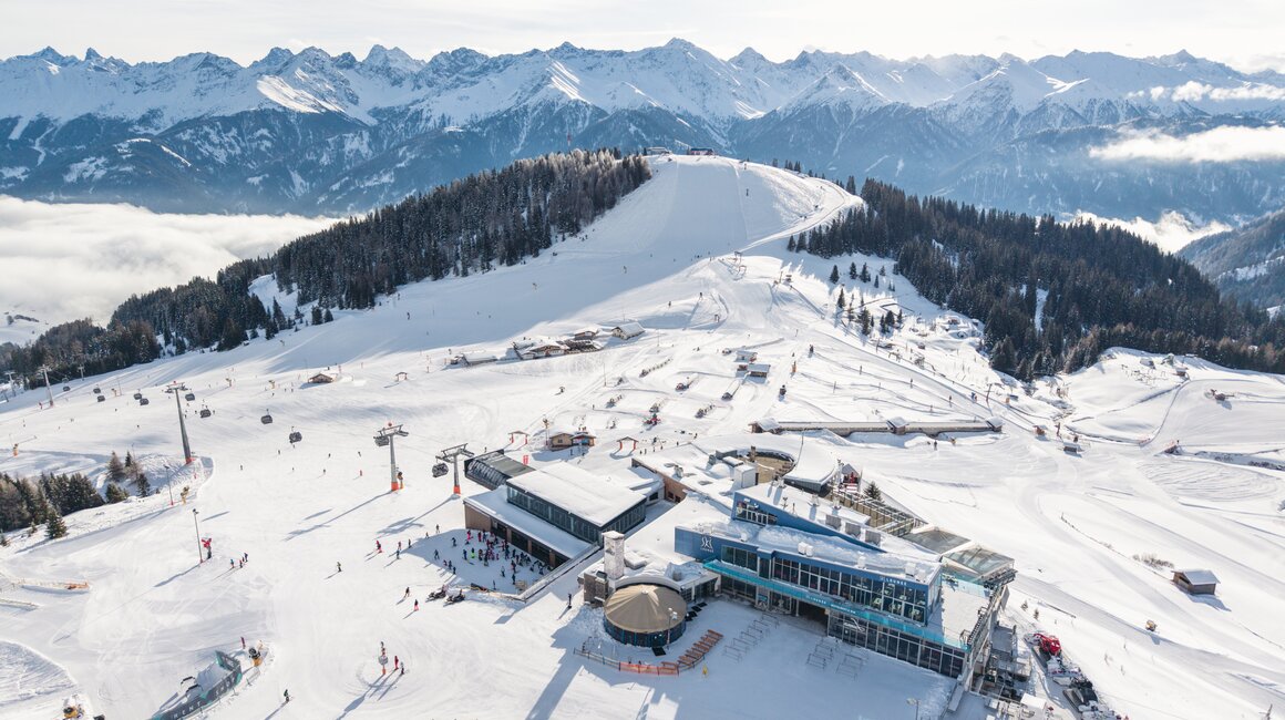 Aerial view of a ski resort with skiers and mountains.