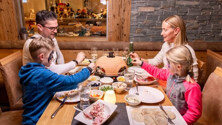 Family has a cozy dinner with various dishes on the table.