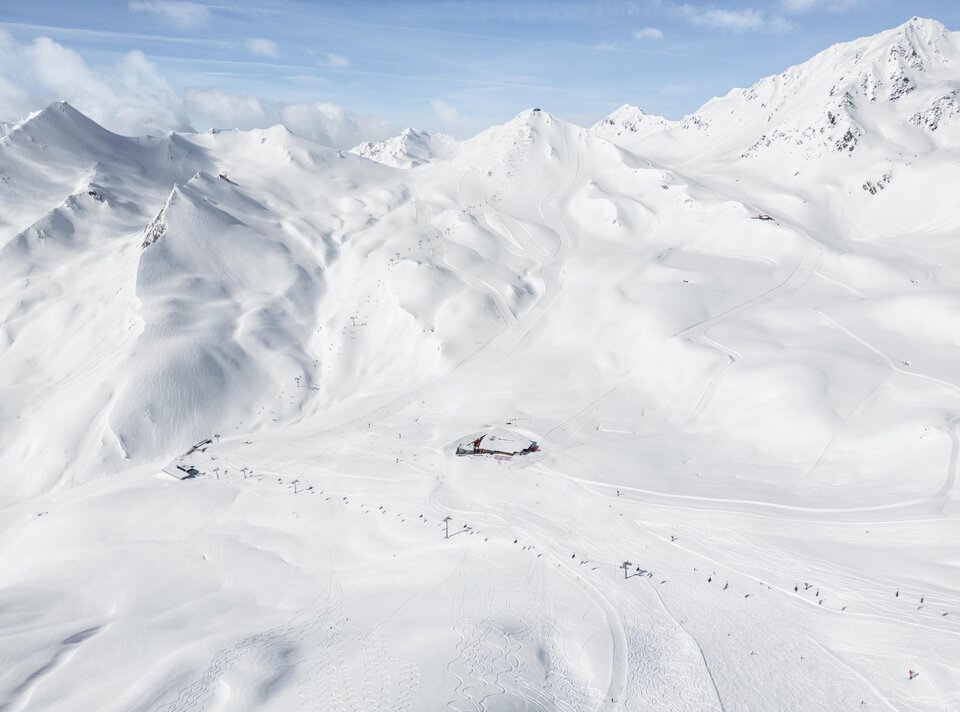 Expansive snow-covered mountains with a ski resort in view.