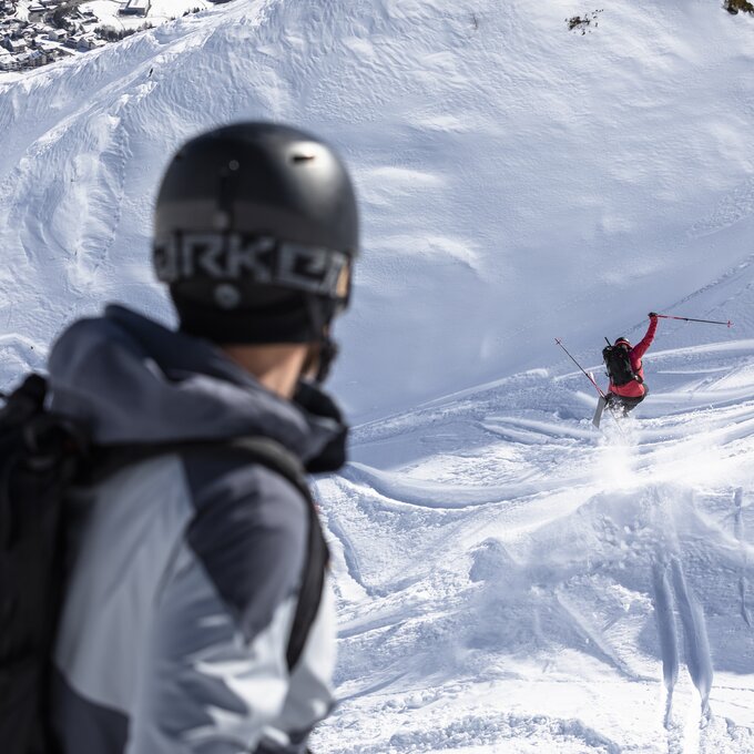 Skifahrer im Pulverschnee mit Blick auf die Berge.