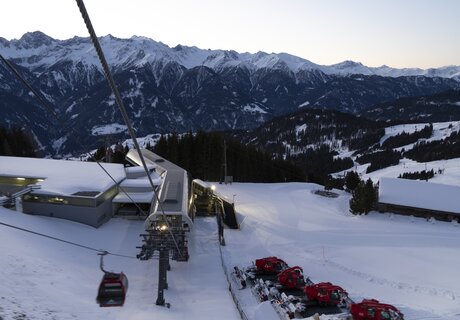 Blick auf schneebedeckte Berge und Gondelbahn im Winter.