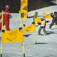 Eine Skitrainingssession für Kinder auf einer Skipiste.