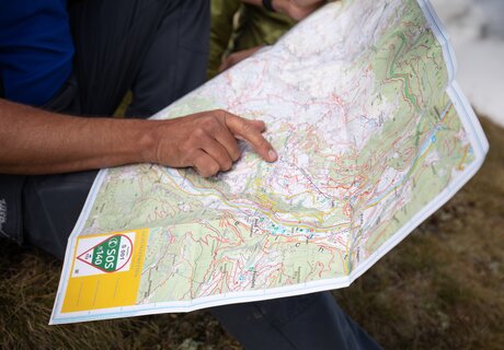 Hand detail pointing at a map of hiking area.