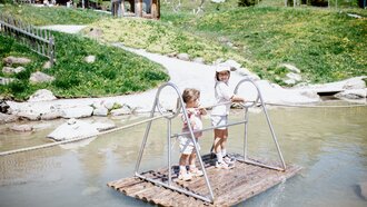 Twee kinderen hebben plezier op een vlot in een klein water.
