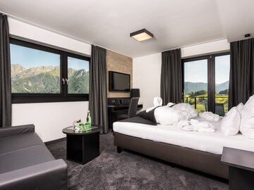 Cozy hotel room with tasteful decor and a view of the mountains.