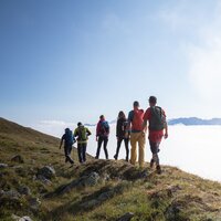 Eine Gruppe von Wanderern auf einem Berg, umgeben von Nebel.