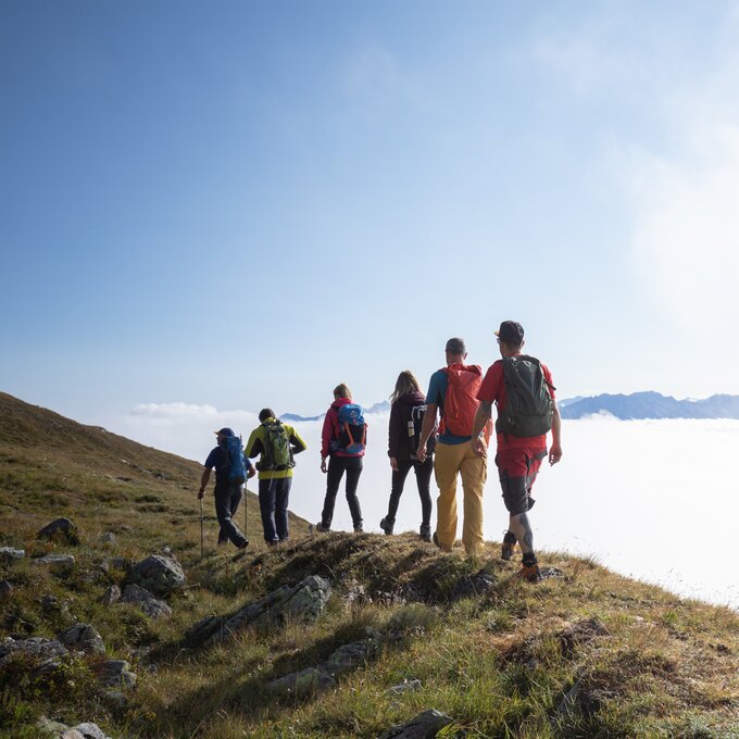 Eine Gruppe von Wanderern auf einem Berg, umgeben von Nebel.