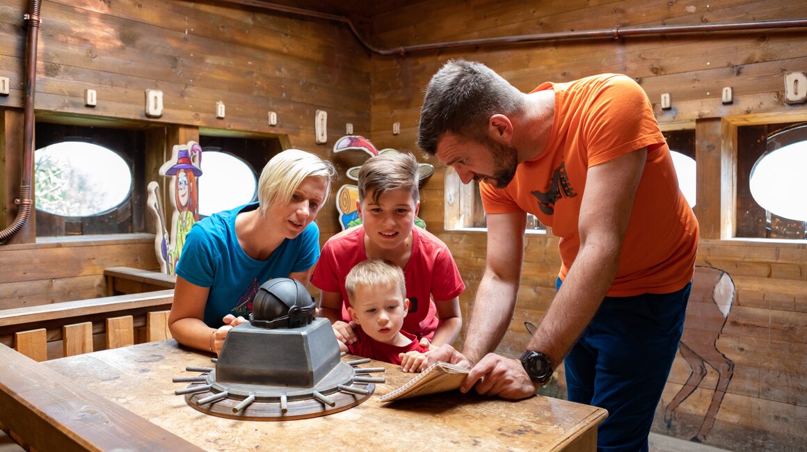 Family solving a riddle in an escape room.