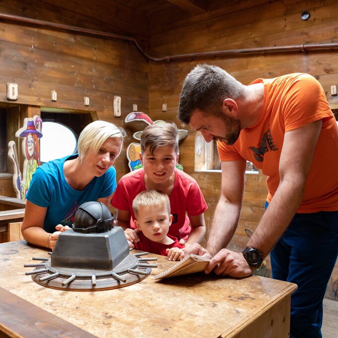 Family solving a riddle in an escape room.