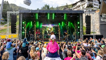 Crowd enjoying a live concert with colorful lights.