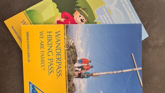 Zwei Broschüren: Wanderpass und Informationsangebot für Wanderer.