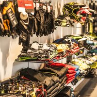 Vielfalt an Schutzhelmen, Handschuhen und Bekleidung in verschiedenen Farben und Größen.