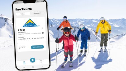 Familie beim Skifahren, Skitickets auf dem Handy.