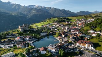 Luchtfoto van een charmant bergdorp met een meer en huizen.