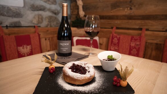 Ein köstliches Dessert mit Beeren und Rotwein auf einem Holzstisch.