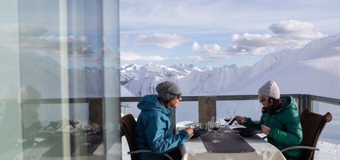 Zwei Personen genießen ein Mittagessen mit Bergblick.