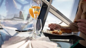 Ein Tisch mit Sekt und leckerem Essen in einem modernen Restaurant.