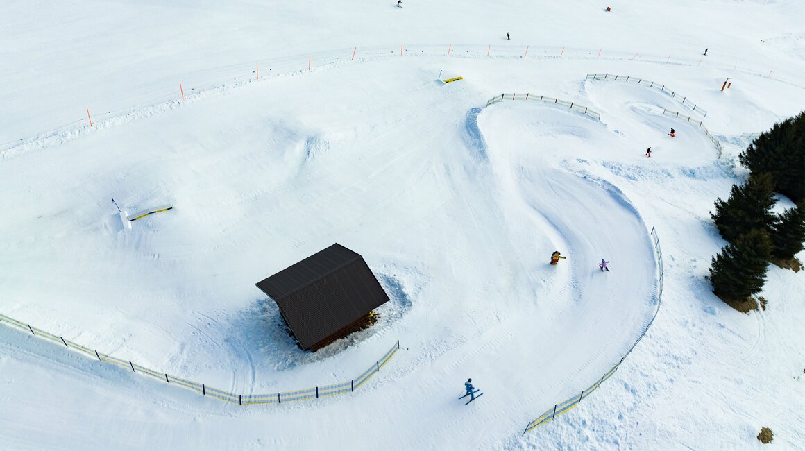 Luchtfoto van een besneeuwd landschap met skiërs.