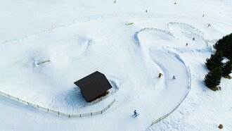 Aerial view of a snowy landscape with skiers.