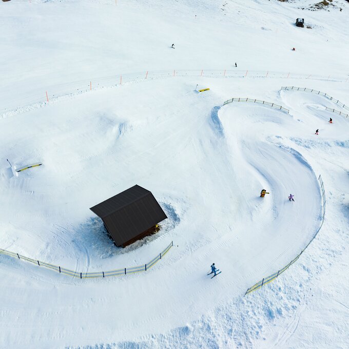 Luftaufnahme einer schneebedeckten Landschaft mit Skifahrern.