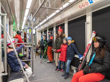Familien und Skifahrer fahren mit der U-Bahn nach einem Skitag.