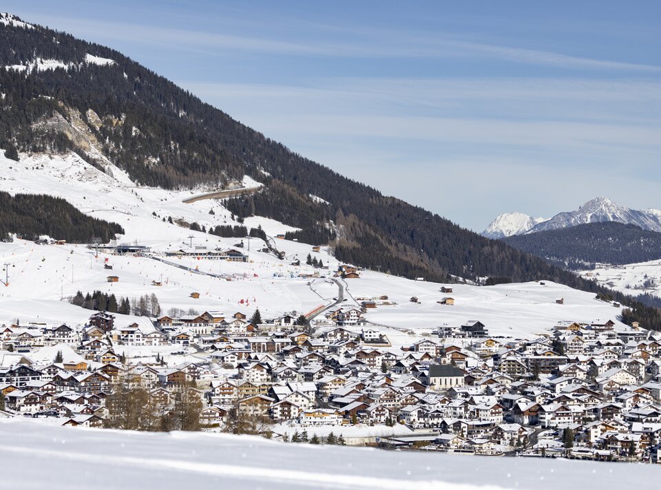 Panorama eines schneebedeckten Dorfes in den Alpen.