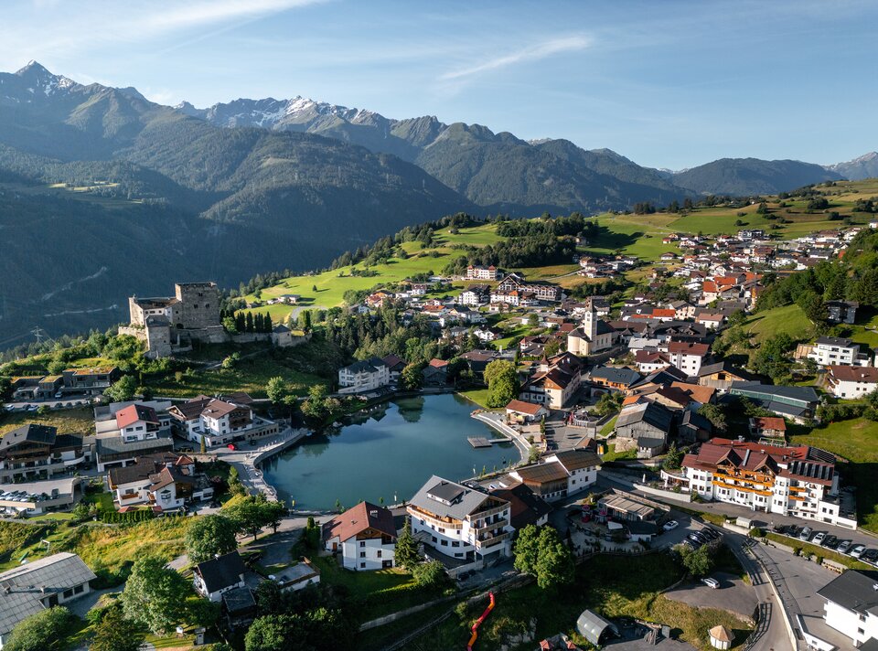 Luftansicht eines charmanten Bergdorfes mit See und Häusern.