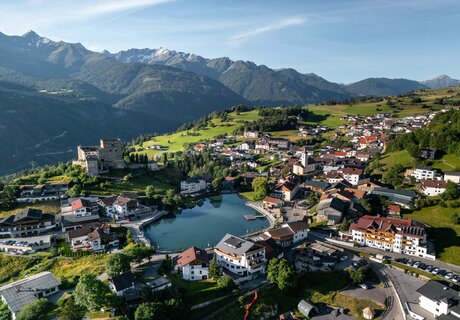 Luftansicht eines charmanten Bergdorfes mit See und Häusern.