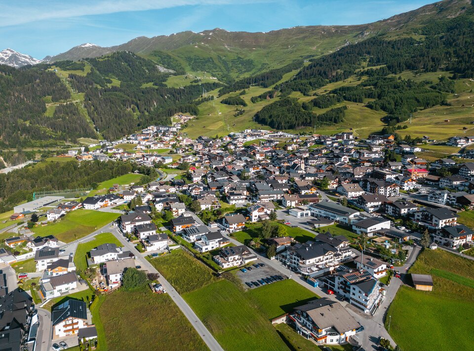 View of a picturesque village in the mountains with green fields.
