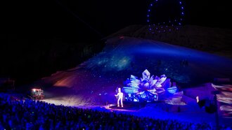 A spectacular night event featuring light effects and an audience.