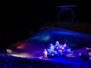 A spectacular night event featuring light effects and an audience.