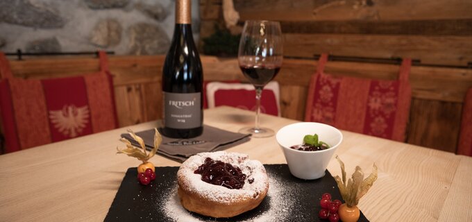 Ein köstliches Dessert mit Beeren und Rotwein auf einem Holzstisch.
