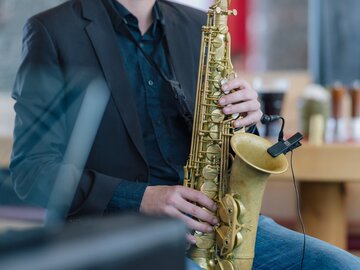 A musician playing saxophone in a modern café.