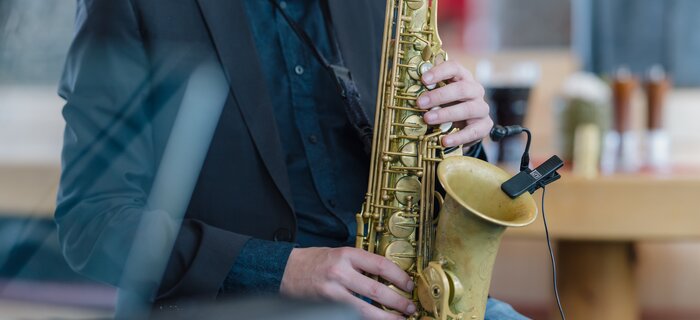 Ein Musiker spielt Saxophon in einem modernen Café.