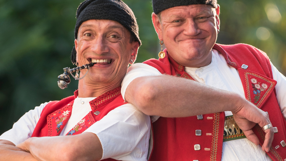 Zwei Männer in traditioneller Kleidung posieren fröhlich.