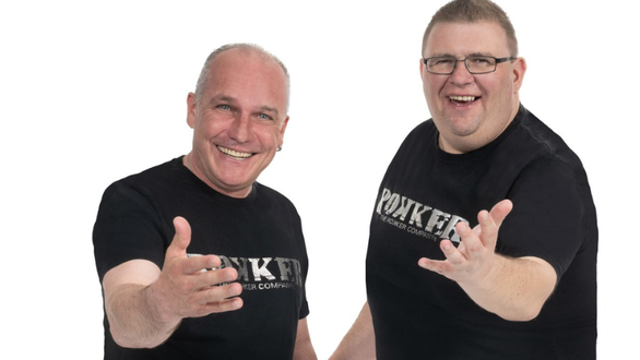 Zwei Männer in T-Shirts posieren freundlich und lächeln.