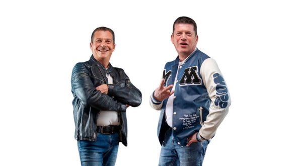 Zwei Männer posieren in legeren Outfits für ein Foto.