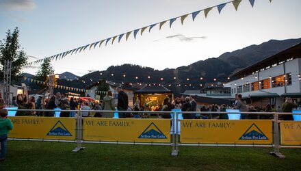 Menschen beim Abendfest mit Musik und bunten Fahnen.