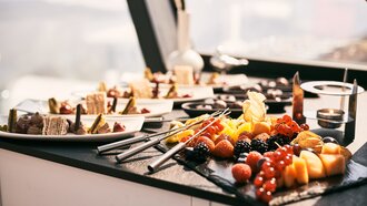 Verschiedene Desserts und frisches Obst auf einem Buffet.