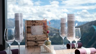 Eleganter Tisch mit Menükarten und Gläsern, Blick auf die Berge.