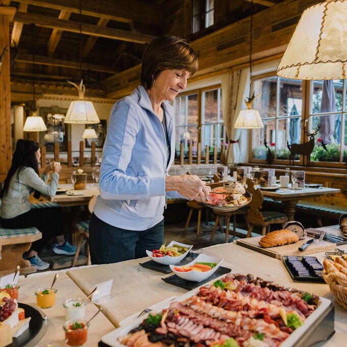 Eine Frau serviert sich Speisen von einem Buffet.