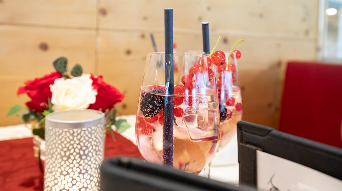 Gläser mit Beeren und schimmerndem Licht auf dem Tisch.
