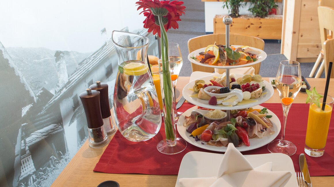 Ein stilvoll gedeckter Tisch mit Obst, Getränken und einer Blume.